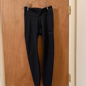 Nike womens dri fit black leggings with thigh/offset pocket.